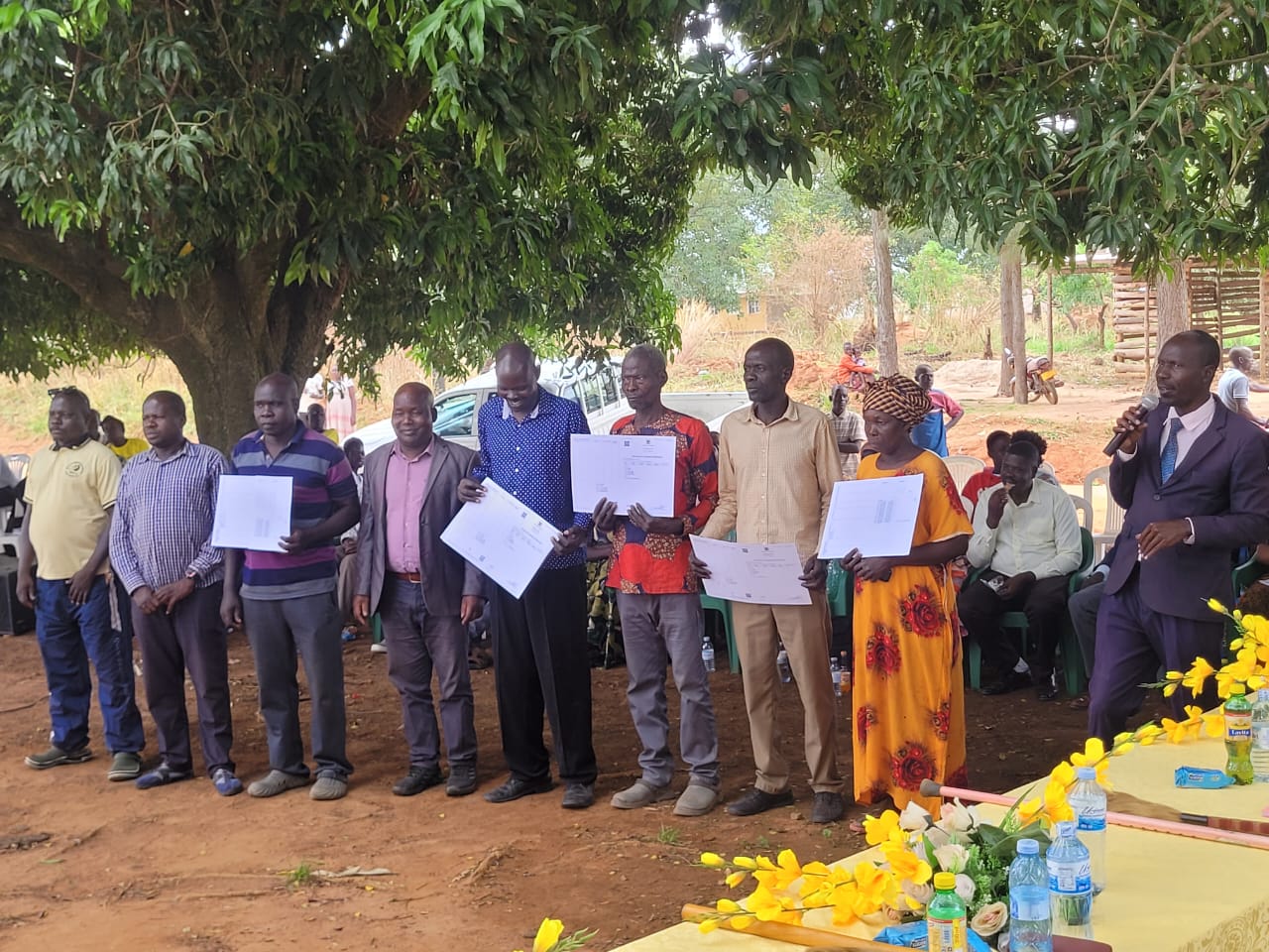 Some of the beneficiaries of the customary land certificate proudly displaying their received certificates.